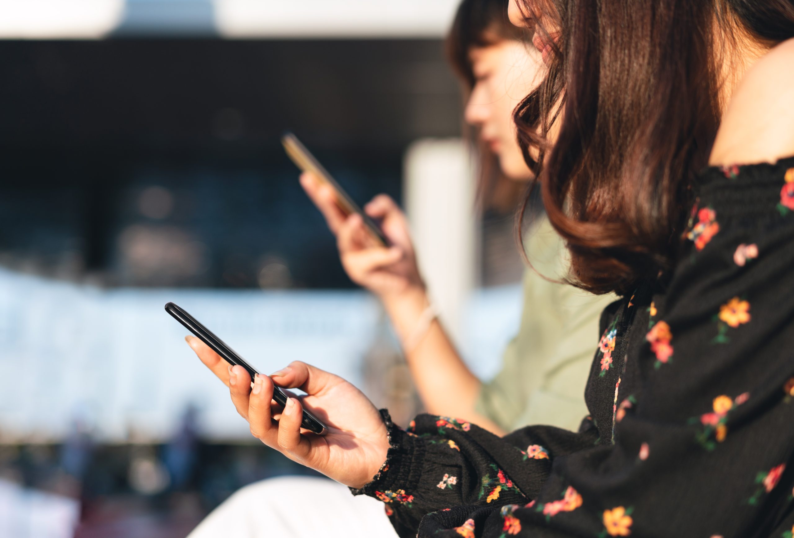 MIDSECTION OF WOMAN USING SMART PHONE